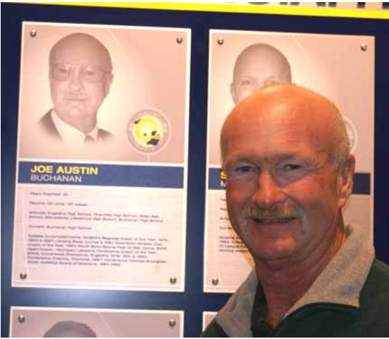 Joe Austin standing next to his Wall of Fame plaque